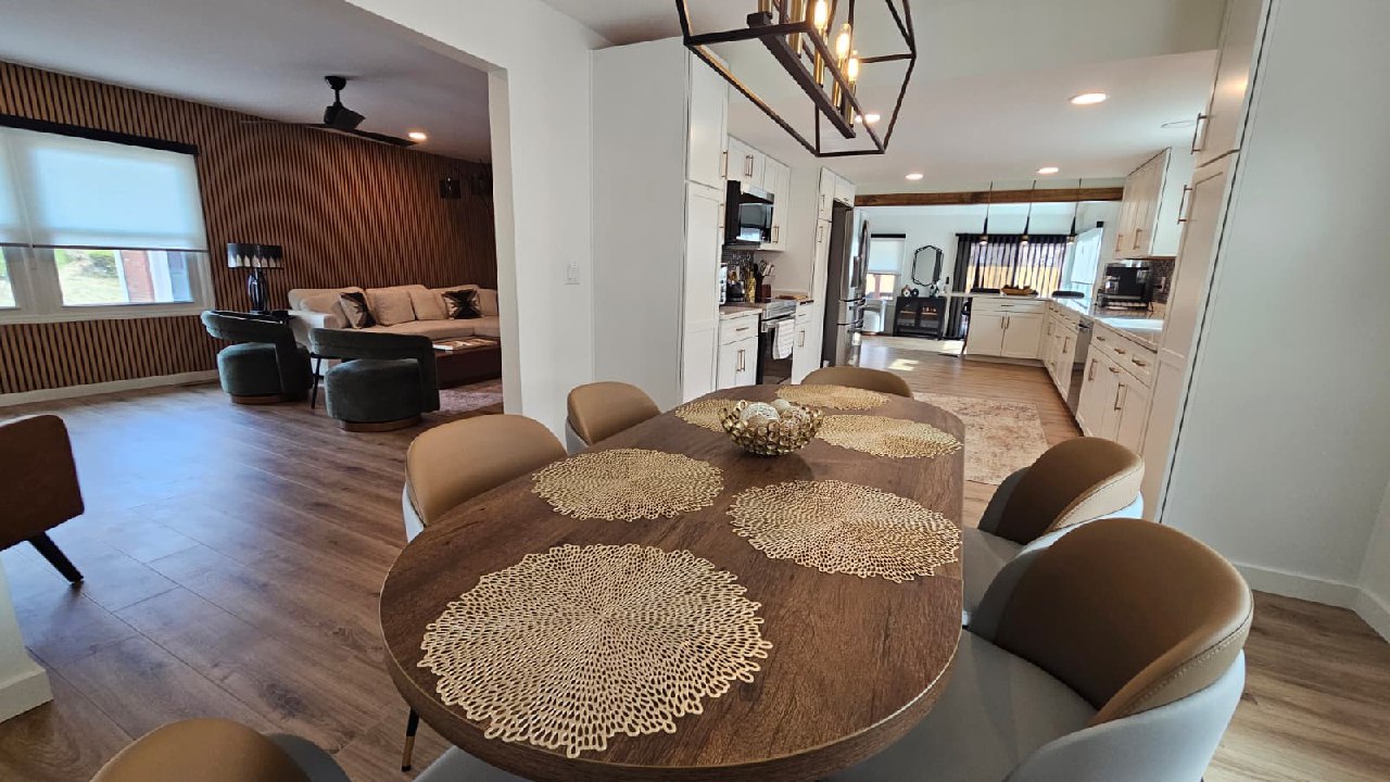 Dining area with round wood table and designer pendant lights